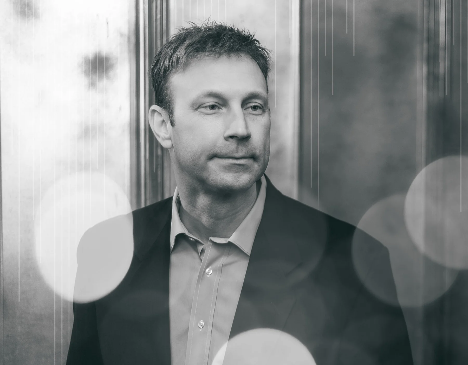 Portrait of Bruce Eicher beside a window.