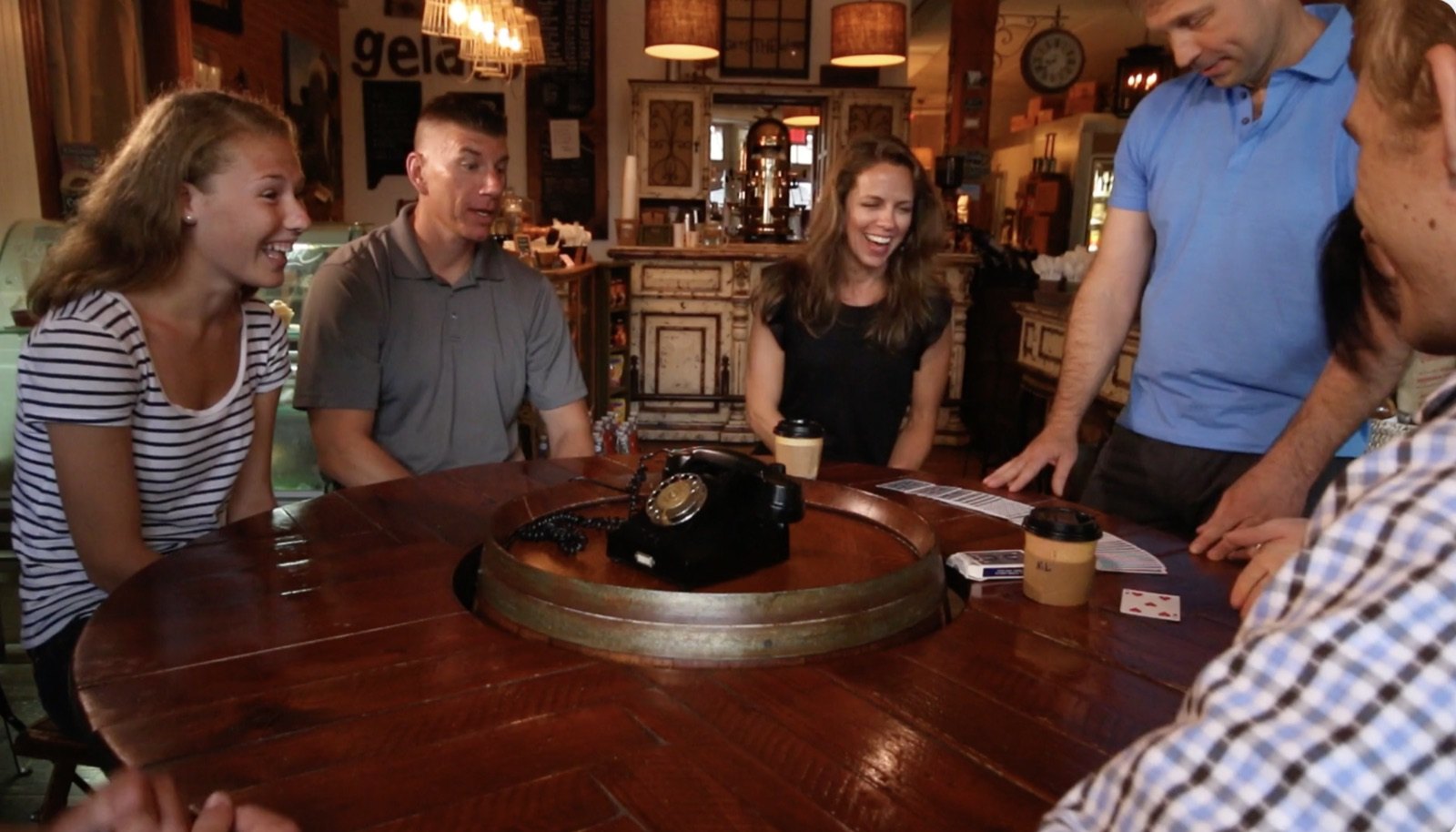 Guests laughing and reacting around a table during Bruce Eicher’s close-up magic.